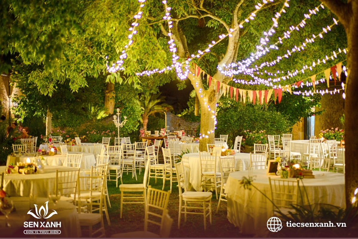 Trang tr&iacute; b&agrave;n tiệc ngo&agrave;i trời với đ&egrave;n d&acirc;y v&agrave; hoa tươi.